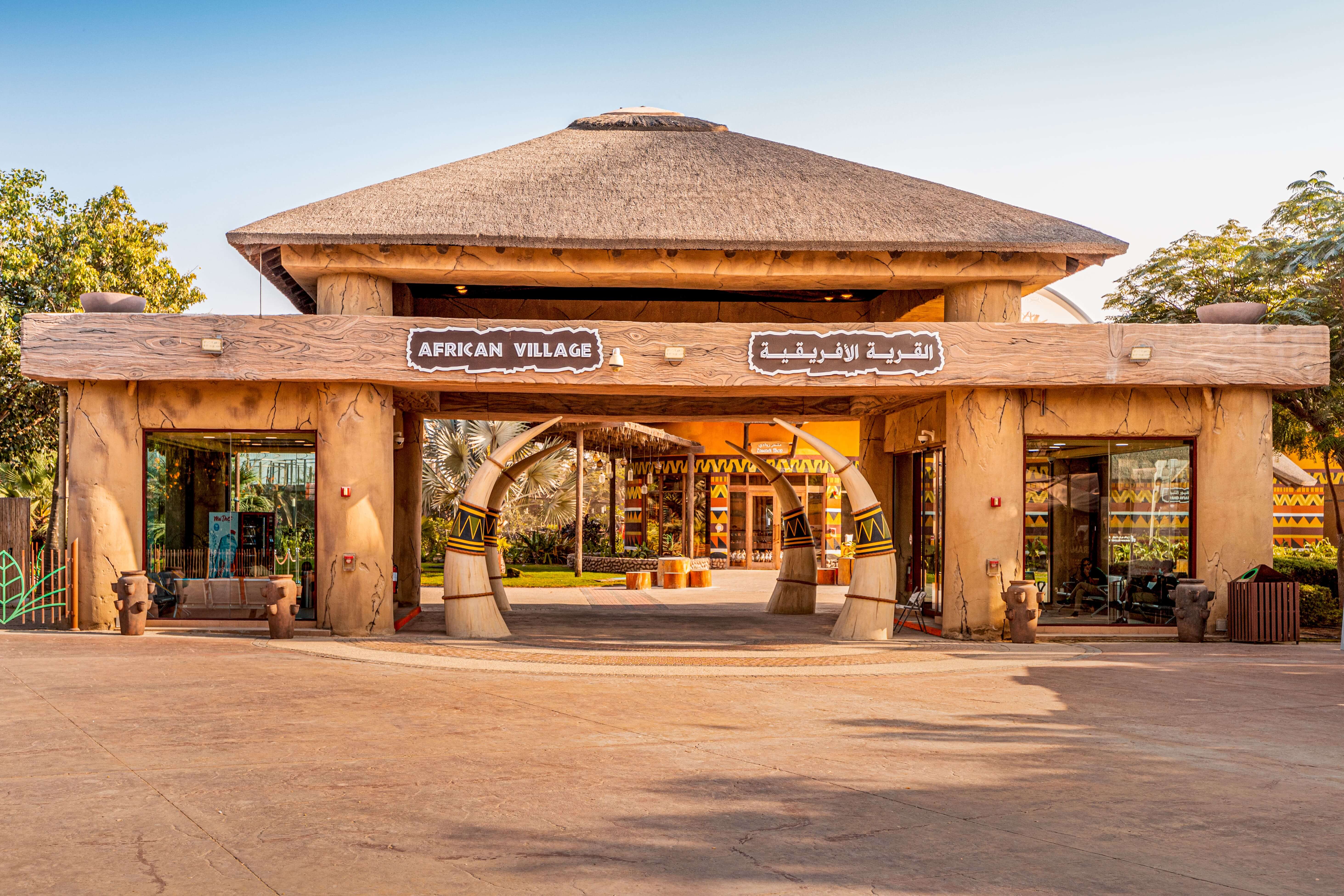 Visitors and tourists with families and children enter the gates of the African Village at Dubai Zoo